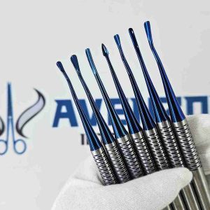 Gloved hand holding blue titanium PDL elevators showing various curved, straight, and arrow tip designs.