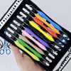 Hand holding black case containing set of colorful silicone dental composite instruments.