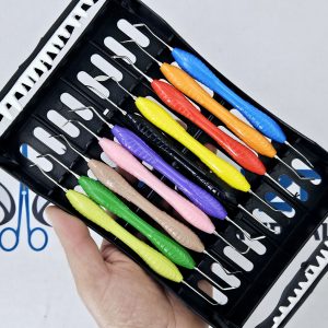 Hand holding black case containing set of colorful silicone dental composite instruments.