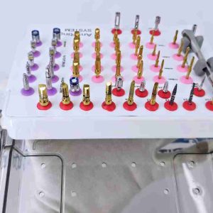 Side view of AnyRinge System dental implant kit tray attached to a stainless steel sterilization box.