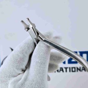 Gloved hand holding orthodontic aligner accent plier for clear tray modification