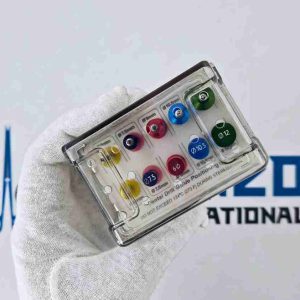 Hand holding closed dental drill guide positioning kit in clear lid autoclavable sterilizing box.