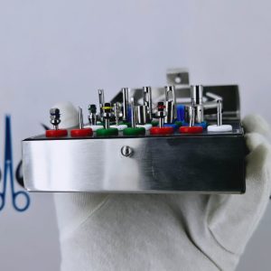 Side view of open 18-piece dental implant remover kit showing color-coded drills, ratchets, and drivers in a steel cassette.