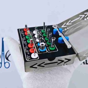 Person holding open surgical dental implant remover kit featuring trephine drills, drivers, and torque wrench.