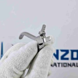 Close up angle view of grooved metal jaws on professional hair extension pliers held with white glove.